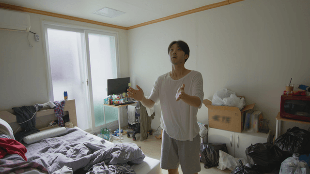 Man catching a bug in a messy room
