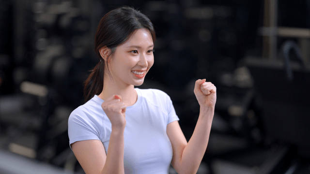 Young woman cheering with a clenched fist in gym