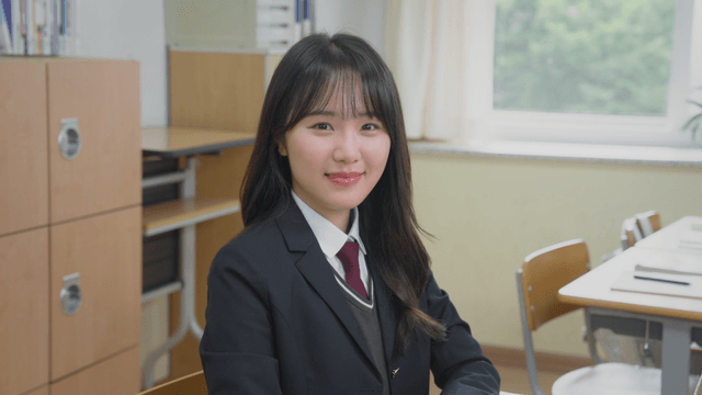 교실에서 작게 미소 짓는 학생