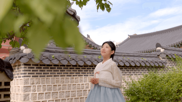 전통 건축물을 감상하는 한복 입은 여성