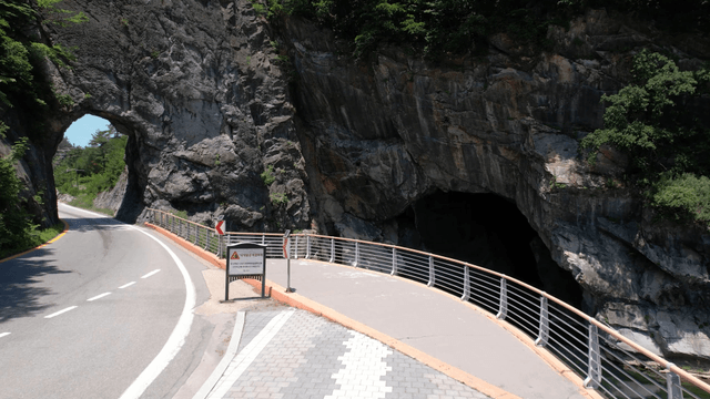 Short tunnel along mountain path through rock wall