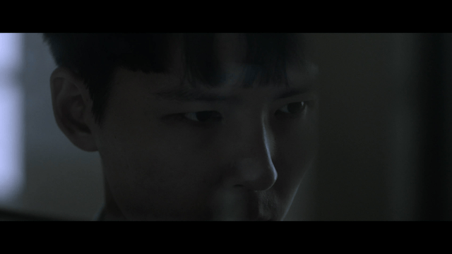 Student concentrating in dark classroom
