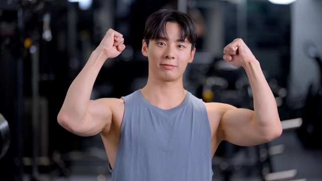 Young man cheering with a smile in a gym