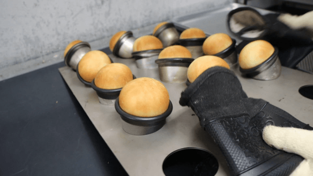 Freshly baked bread being removed from oven