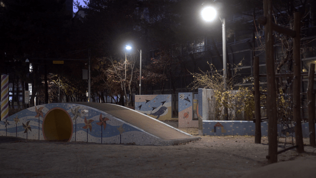 Quiet playground at night with streetlights
