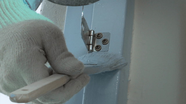 Brush painting precisely beside a door hinge