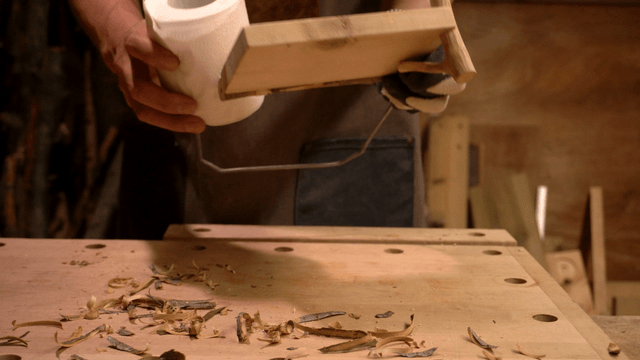 Woodcraft artisan finishing a handmade wooden toilet paper holder