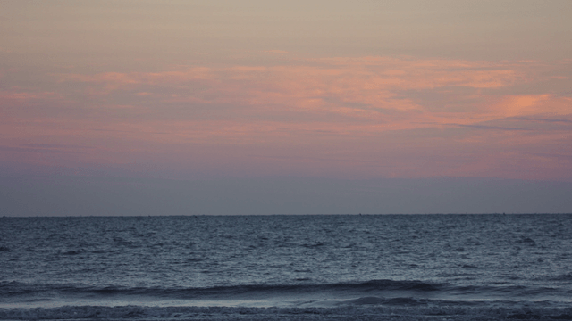 Tranquil sea under a pink sky