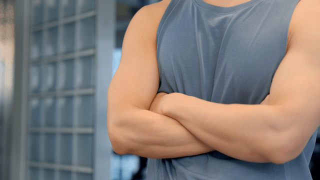 Man in sleeveless shirt posing with crossed arms
