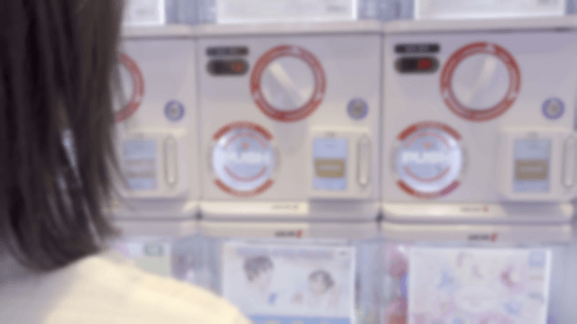 Person looking at gacha machines in a shop