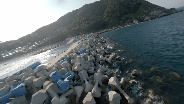 Coastal view with breakwaters and hills