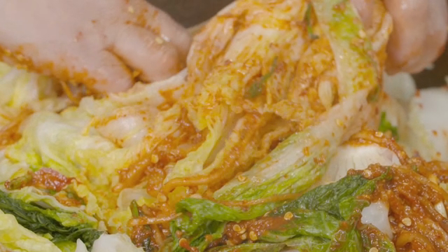 Mixing kimchi with cabbage and spices