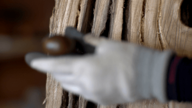 Diligent hands shaping wooden hole with an awl